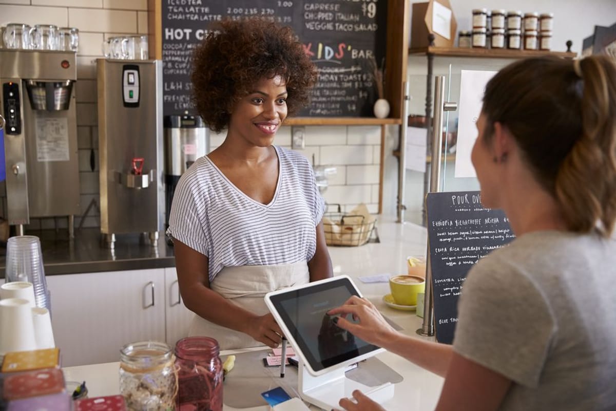 The Perfect Balance The Perfect Balance | Image of smiling cashier service a customer