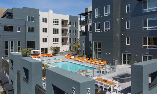 rooftop patio and pool with a building behind it