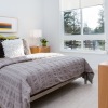bedroom with bed dresser fan and windows