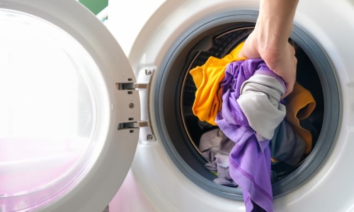 Someone pulling clothes from a dryer